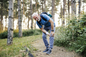 Older man pauses on a walk due to leg pain from peripheral artery disease